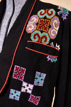 Load image into Gallery viewer, Vintage 1980&#39;s black and red embroidered cross stitch blazer is shown in close up. This folksy jacket has colorful needlepoint designs. 
