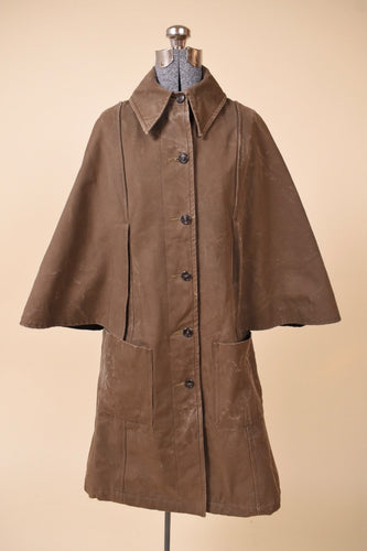 Vintage 1960's olive French waxed canvas cape sleeve rain jacket is shown from the front. This long cape jacket has a pointed collar. 