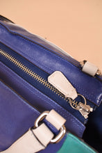 Load image into Gallery viewer, Vintage Y2K colorblock blue and green bag is shown from above. This bag has a zipper. 
