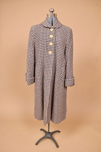Vintage 1950's pale pink and navy houndstooth wool swing coat is shown from the front. This swing coat has four cream buttons at the collar. 