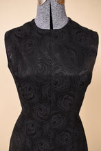 Load image into Gallery viewer, Vintage black jacquard swirl print tunic dress by Plymouth is shown in close up. This vintage sixties slit shift dress has a seam up the center. 
