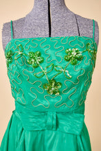 Load image into Gallery viewer, Vintage 60&#39;s emerald green sequin acetate mini dress is shown in close up. This dress has a sequin squiggle design on the bust with green sequin flowers. 
