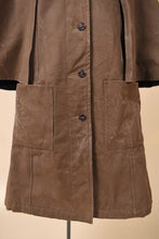 Load image into Gallery viewer, Vintage long 60s olive green waxed raincoat is shown in close up. 
