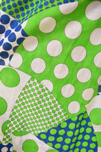 Load image into Gallery viewer, Vintage sixties psychedelic polka dot print maxi skirt is shown in close up. This skirt has green, blue, and white patchwork polka dot prints. 
