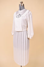 Load image into Gallery viewer, Vintage 80&#39;s sheer pleated white midi dress is shown from the side. This dress has a lace applique on the bust. 
