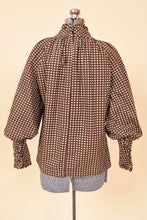 Load image into Gallery viewer, Vintage seventies brown and white daisy print cottagecore blouse is shown from the back. This brown blouse has a tiny white floral daisy pattern. 
