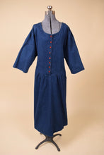 Load image into Gallery viewer, Vintage 1980s union-made buttoned navy denim dress is shown from the front. This dark wash denim dress has red plastic buttons down the front. 
