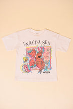 Load image into Gallery viewer, Vintage white cropped single stitch 80&#39;s Unda Da See little mermaid shirt is shown from the front. 
