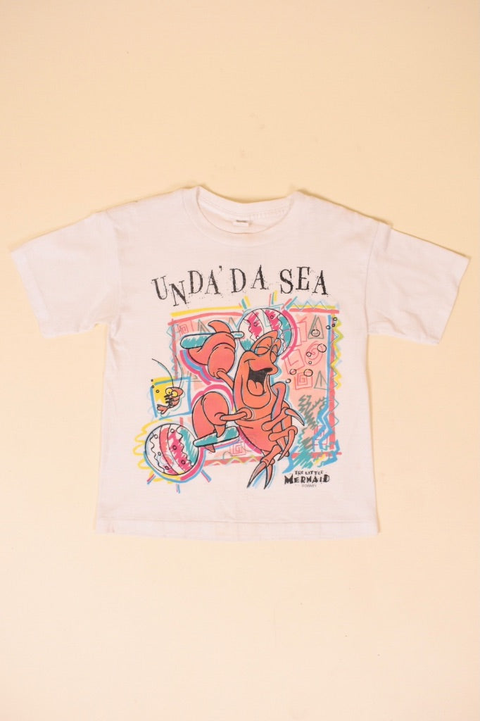 Vintage white cropped single stitch 80's Unda Da See little mermaid shirt is shown from the front. 