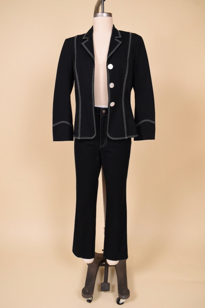 Vintage Escada two piece pantsuit with white contrast stitching is shown from the front. This western inspired suit has abalone buttons down the front. 