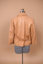 Load image into Gallery viewer, Vintage light brown leather jacket is shown from the back. This jacket has a belt detail at the back. 
