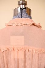 Load image into Gallery viewer, Vintage frilly lace trim silk crepe peach button down is shown from the back. This top is made from a sheer material. 
