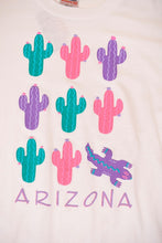 Load image into Gallery viewer, Vintage eighties white Arizona graphic tourist tee shirt is shown in close up. This tee shirt has a colorful cactus and lizard graphic.
