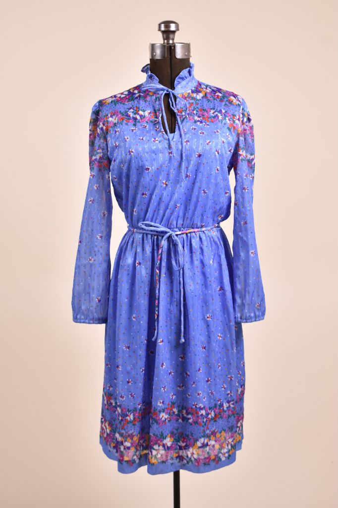 Vintage 1970's blue floral boho dress is shown from the front. This floral print dress has a keyhole neckline. 