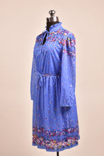 Load image into Gallery viewer, Vintage 70&#39;s cobalt blue polyester floral dress is shown from the side. This dress has a ruffled collar. 
