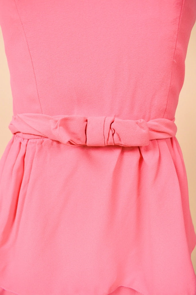 Vintage XXS pink party dress is shown in close up. 