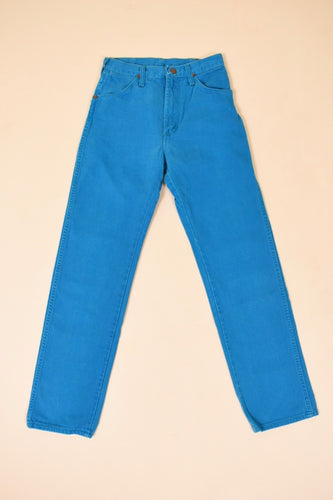 Vintage bright turquoise straight leg 80s jeans by Wrangler are shown from the front. 
