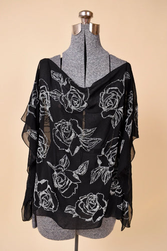 Vintage black sheer flowy top is shown from the front. This top has white floral beaded rose designs. 