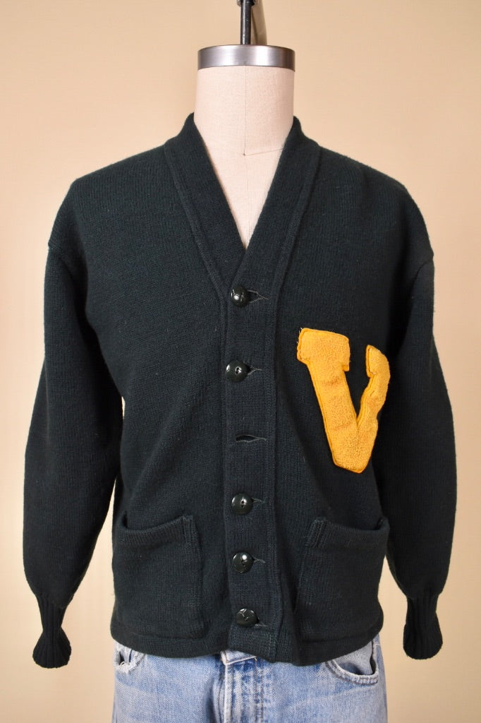 Vintage 1940's forest green UVM letterman sweater by Lanza is shown from the front. This green sweater has a yellow V on the front. 