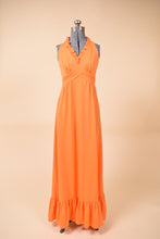 Load image into Gallery viewer, Vintage orange polyester 1970&#39;s ruffled maxi length gown is shown from the front. This dress has an empire waist.
