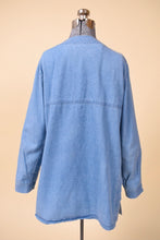 Load image into Gallery viewer, Vintage 1990&#39;s blue denim button down top is shown from the back. This oversized blue denim top is collarless. 

