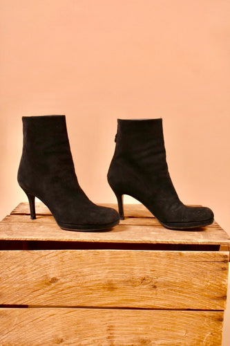The side of the boots raised on a platform. The shoes are tall ankle boots and have a stiletto heel.