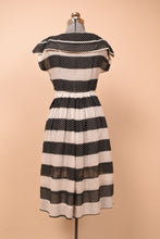 Load image into Gallery viewer, Vintage fifties striped black and white dot dress is shown from the back. This dress has short sleeves.
