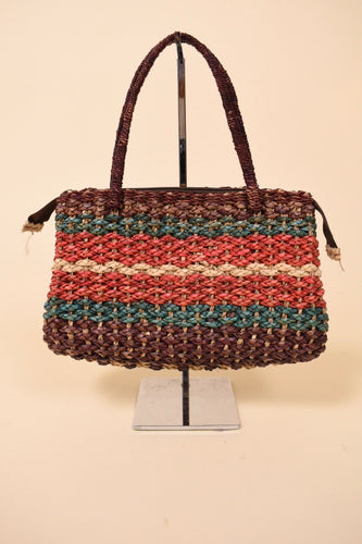 Vintage colorful striped woven seagrass handbag is shown from the front. This woven bag has maroon, blue, and red dyed seagrass. 