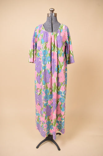 Vintage 1970's floral print pastel maxi dress is shown from the front. This dress has a gathered neckline with pleats. 