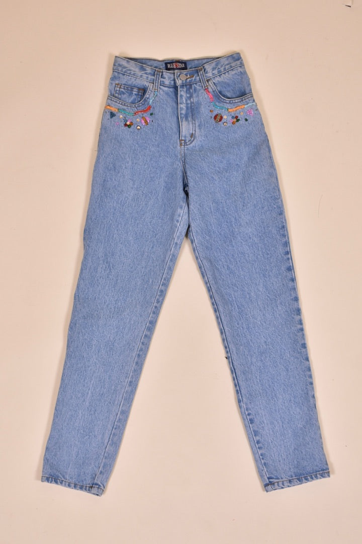 Vintage 1990's lightwash beaded denim jeans are shown from the front. 