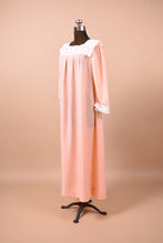 Load image into Gallery viewer, Vintage peach long nightgown shown from the side. This dress has lace trim at the bottom of the sleeves.
