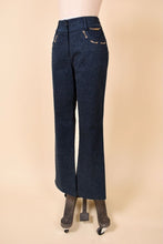 Load image into Gallery viewer, Vintage 2000&#39;s navy denim boot cut jeans are shown from the side. These designer St John jeans have delicate gold chain accents on the pockets. 
