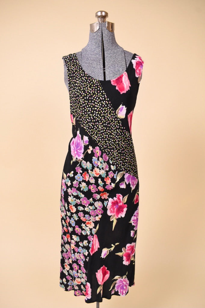 Vintage 1990's black floral print rayon midi dress is shown from the front. This dress has a scoop neckl. 
