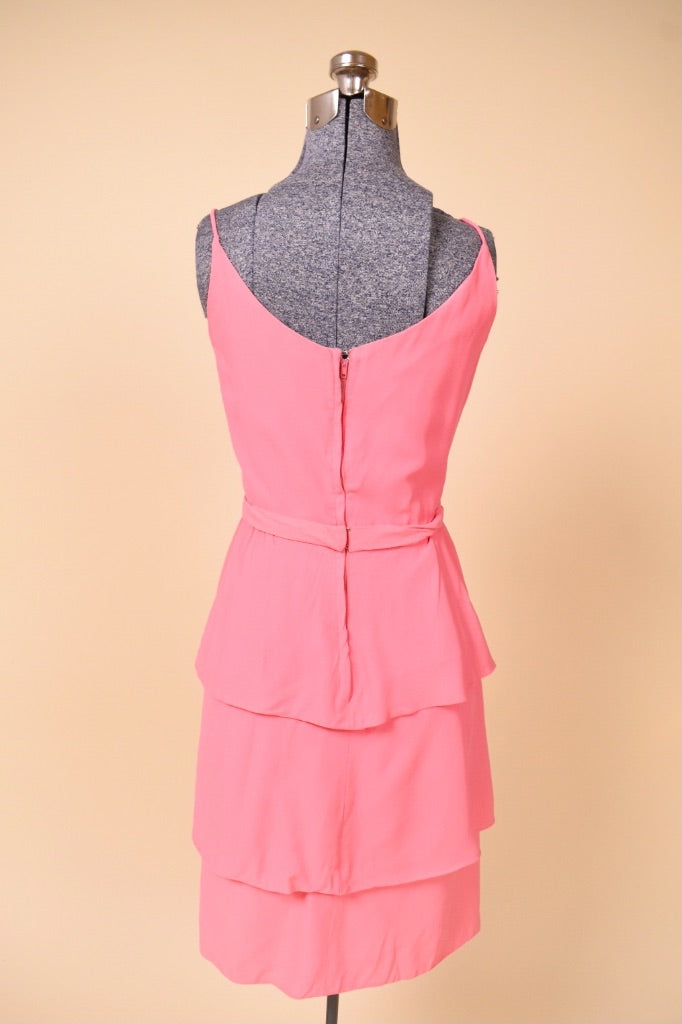 Vintage pink ruffle skirt mini dress is shown from the back. This vintage party dress has a metal zipper down the back. 