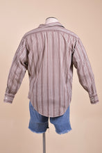 Load image into Gallery viewer, Vintage men&#39;s brown and white striped button down is shown from the back. 
