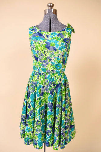Vintage 1960's blue and green painterly floral day dress by Jay Herbert is shown from the front. This dress has a cute bow detail at the shoulder.