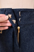 Load image into Gallery viewer, Vintage designer St John navy and gold mid rise jeans are shown in close up. These jeans have two hooks at the waistband. 
