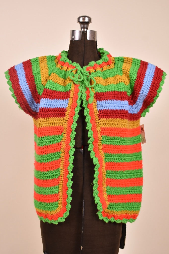Vintage handmade knit colorful stripe cardigan is shown from the front. This cardigan is green, orange, blue, and maroon.