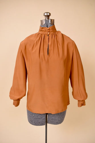 Vintage 1980's copper colored silk keyhole blouse is shown from the front. This blouse has three shiny buttons at the neckline. 