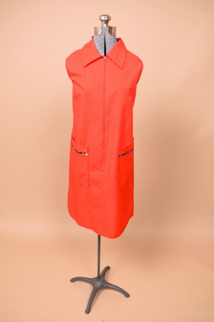 Vintage 1970's red smock house dress shown from the front. This dress has a pointed collar.