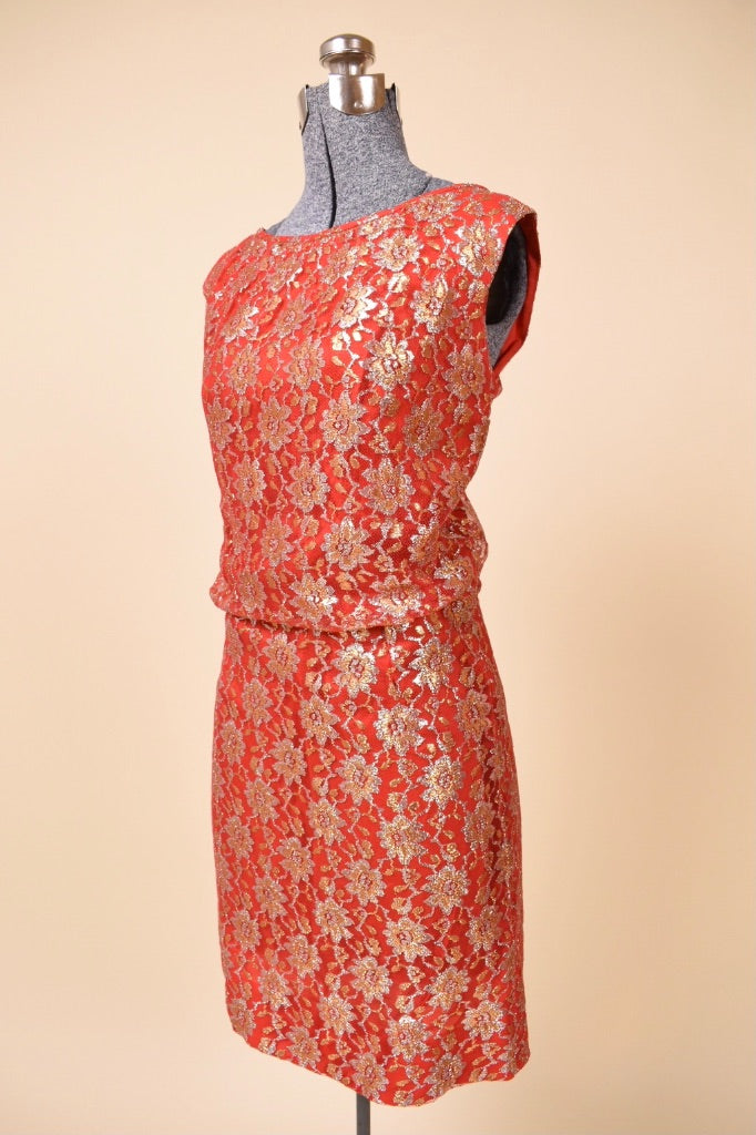 Vintage 60's red mini dress by Algo is shown from the side. This dress has a sparkly gold lace overlay. 