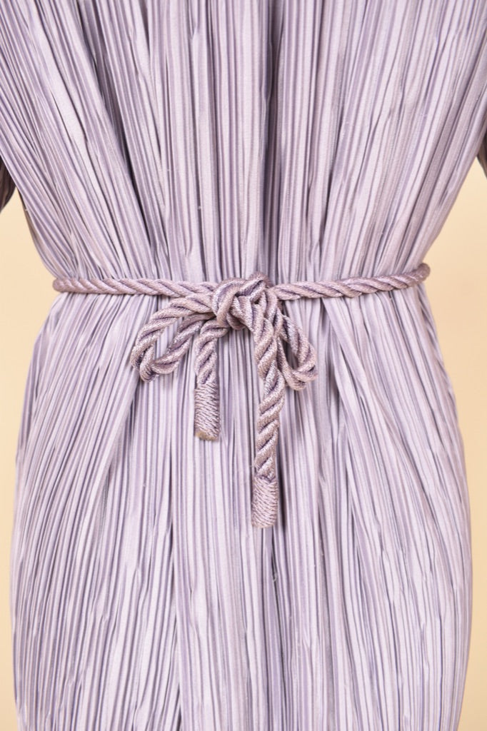 Vintage purple French designer midi pleated dress is shown in close up. This dress has a slight sheen. 