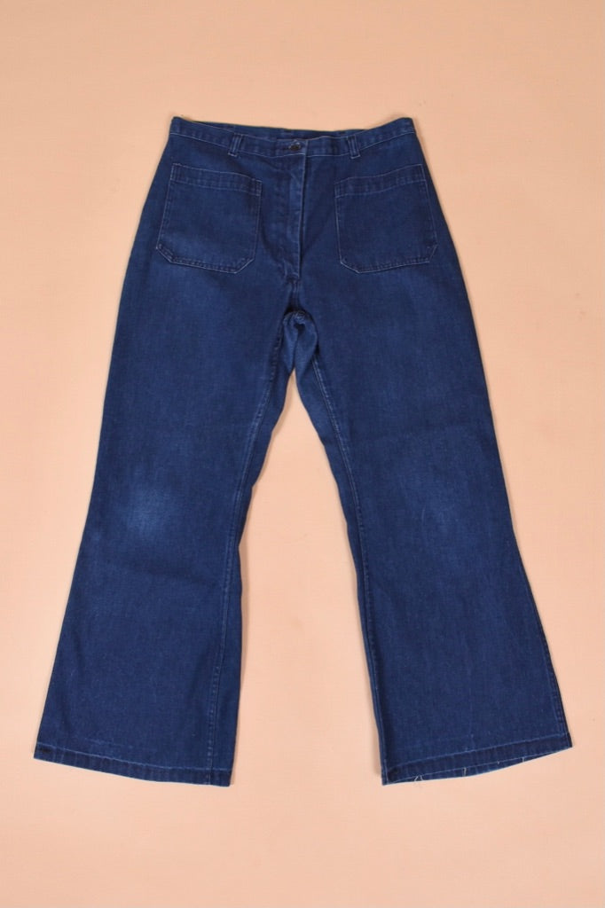 Vintage 1970's dark blue flare jeans are shown from the front. These wide leg flare jeans have two large square front pockets.