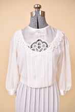Load image into Gallery viewer, Vintage 80s white sheer floral lace bib dress is shown in close up. 
