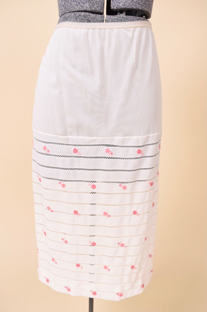 Vintage white midi length lingerie skirt by Eyeful is shown from the front. This skirt has pink rose embroidery on the skirt. 