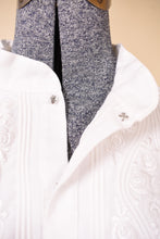 Load image into Gallery viewer, Vintage white cotton embroidered puff sleeve flowy blouse is shown in close up. This blouse has a snap at the collar. 
