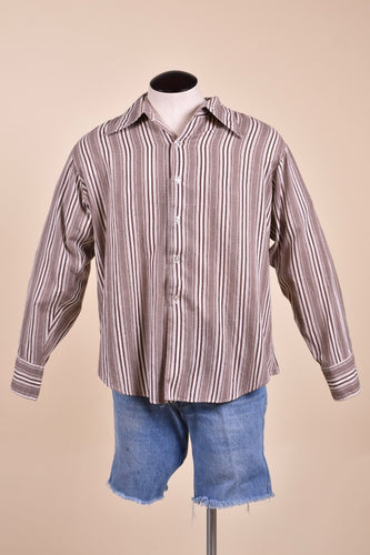Vintage 1970's men's brown and white vertical stripe button down top is shown from the front. This dress shirt has a pointed collar. 