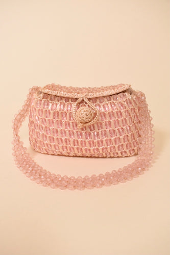 Light pink beaded raffia bag by Gaymode is shown from the front. This bag is made from chunky clear shiny pink beads. 