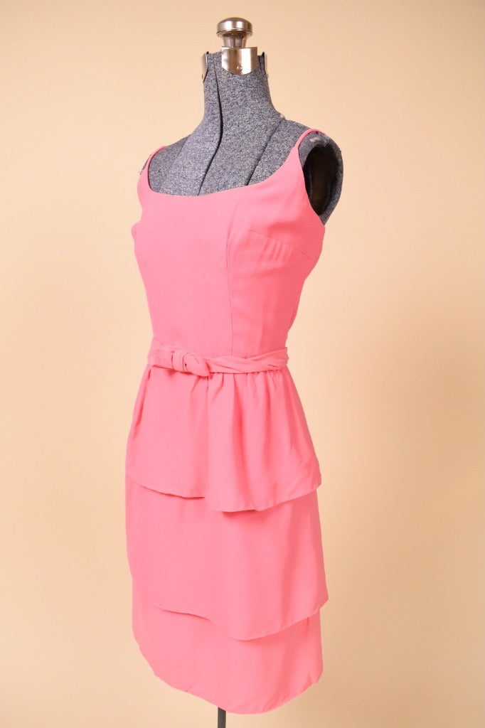 Vintage pink tiered skirt party dress by Ann Barry is shown from the side. This dress has a wide scoop neckline. 