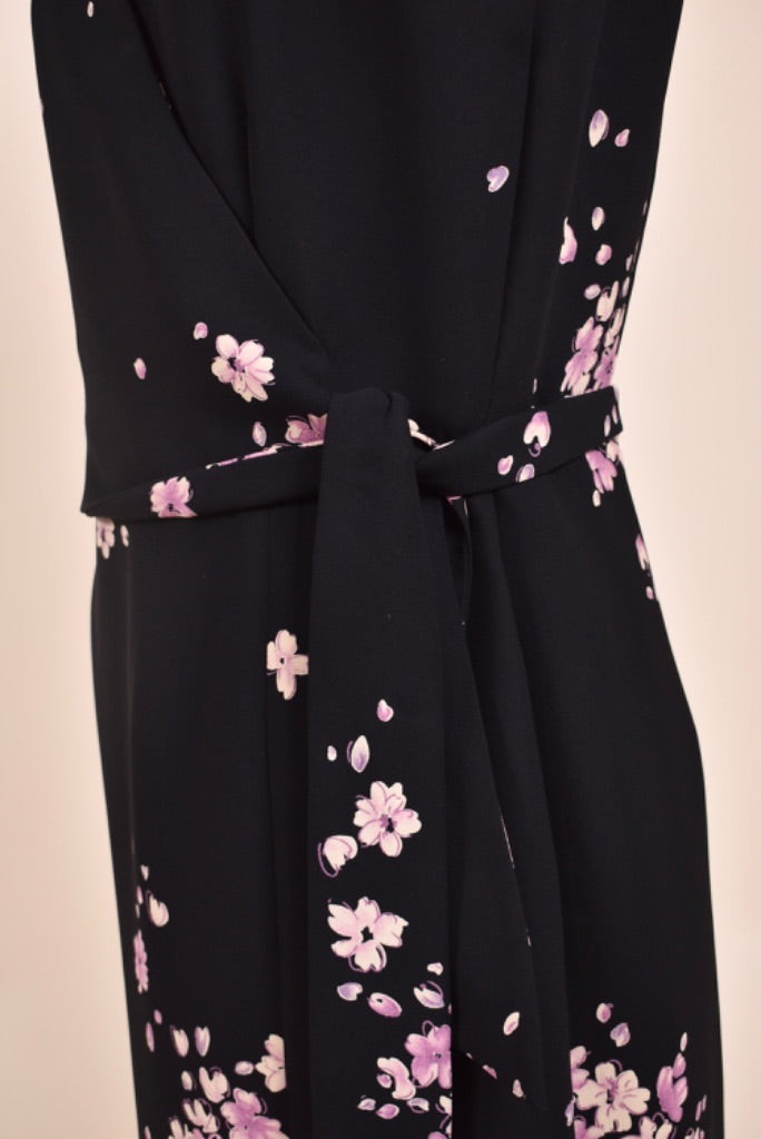 Vintage black and pastel pink polyester floral dress is shown in close up. 